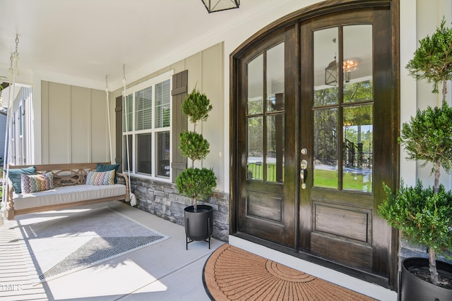 143 Sallyport Ct, Raleigh, NC 27603 - property entrance with french doors, stone siding, and covered porch