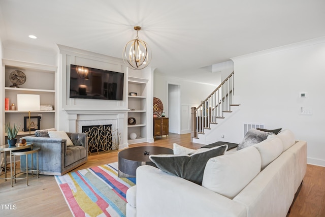 143 Sallyport Ct, Raleigh, NC 27603 - living room with a fireplace, ornamental molding, visible vents, wood finished floors, and stairs