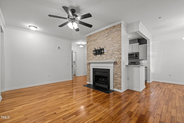 8231 Allyns Landing Way Unit 101, Raleigh, NC 27615 - unfurnished living room with crown molding, light wood-type flooring, a ceiling fan, and a fireplace