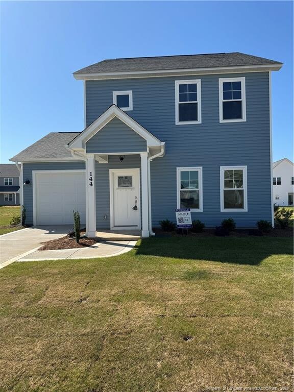 view of front of property with a front lawn, an attached garage, and concrete driveway