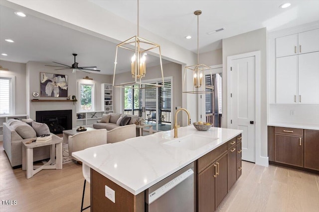 337 Merrywood Dr, Raleigh, NC 27610 - kitchen with an island with sink, visible vents, stainless steel dishwasher, a sink, and light wood-style floors