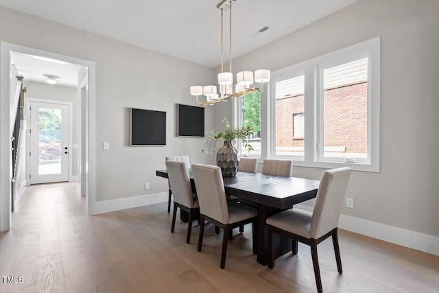 337 Merrywood Dr, Raleigh, NC 27610 - dining space featuring light wood-style floors, baseboards, and an inviting chandelier