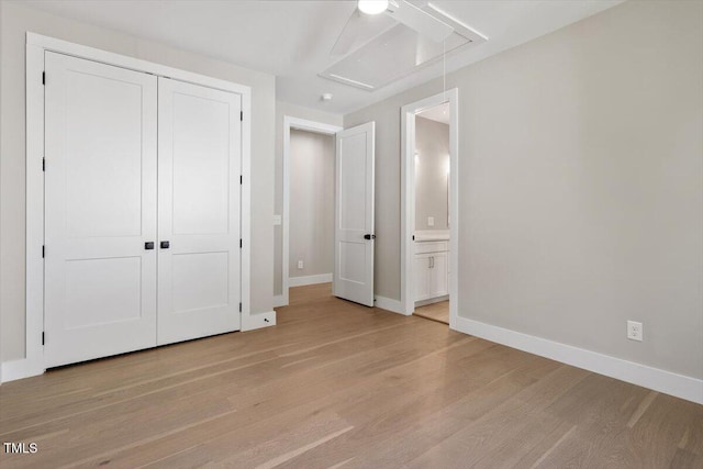 337 Merrywood Dr, Raleigh, NC 27610 - unfurnished bedroom featuring a closet, baseboards, attic access, light wood-style flooring, and ensuite bathroom