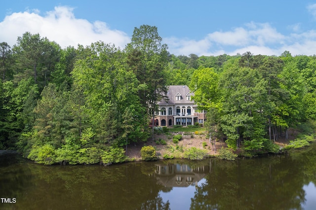 drone / aerial view featuring a view of trees and a water view