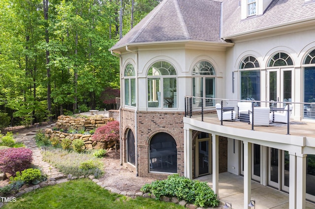 back of property with stucco siding, a patio, and a shingled roof
