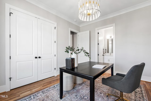 office with wood finished floors, a notable chandelier, baseboards, and ornamental molding