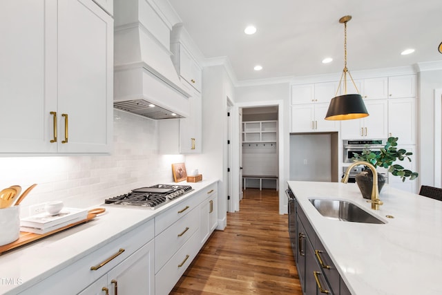 kitchen with white cabinets, decorative backsplash, a sink, and appliances with stainless steel finishes