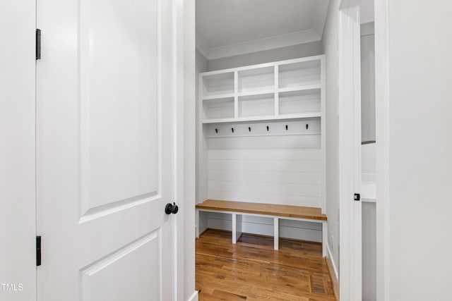 mudroom featuring wood finished floors, visible vents, and crown molding