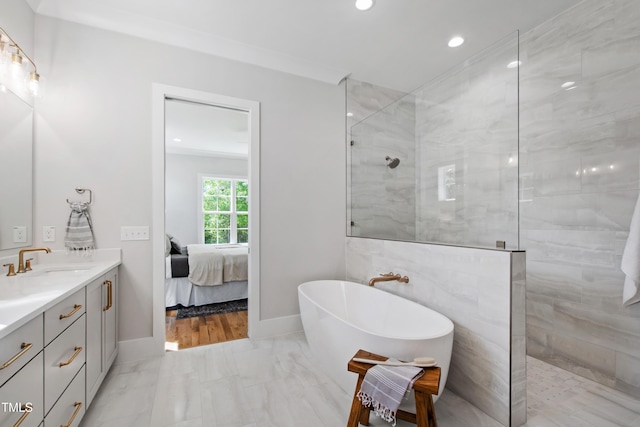 full bathroom featuring marble finish floor, a freestanding bath, vanity, ensuite bath, and walk in shower