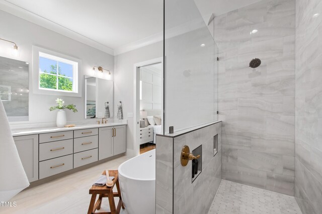 full bathroom featuring vanity, a freestanding bath, walk in shower, ensuite bath, and ornamental molding
