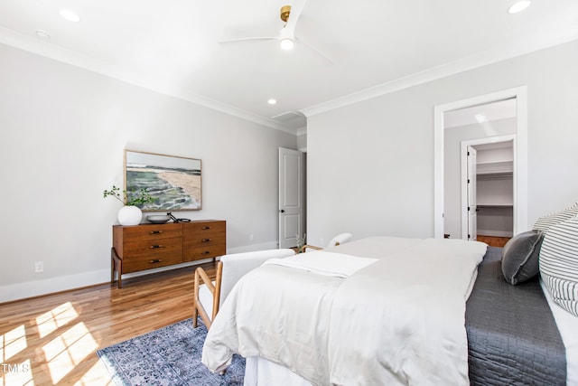 bedroom with wood finished floors, recessed lighting, ceiling fan, and crown molding