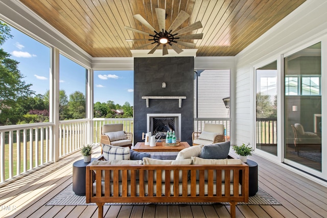 sunroom featuring an outdoor living space with a fireplace, a ceiling fan, and wood ceiling