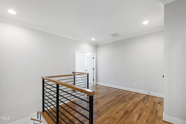 staircase featuring crown molding, wood finished floors, baseboards, visible vents, and recessed lighting