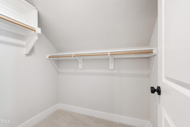 walk in closet featuring carpet floors and lofted ceiling
