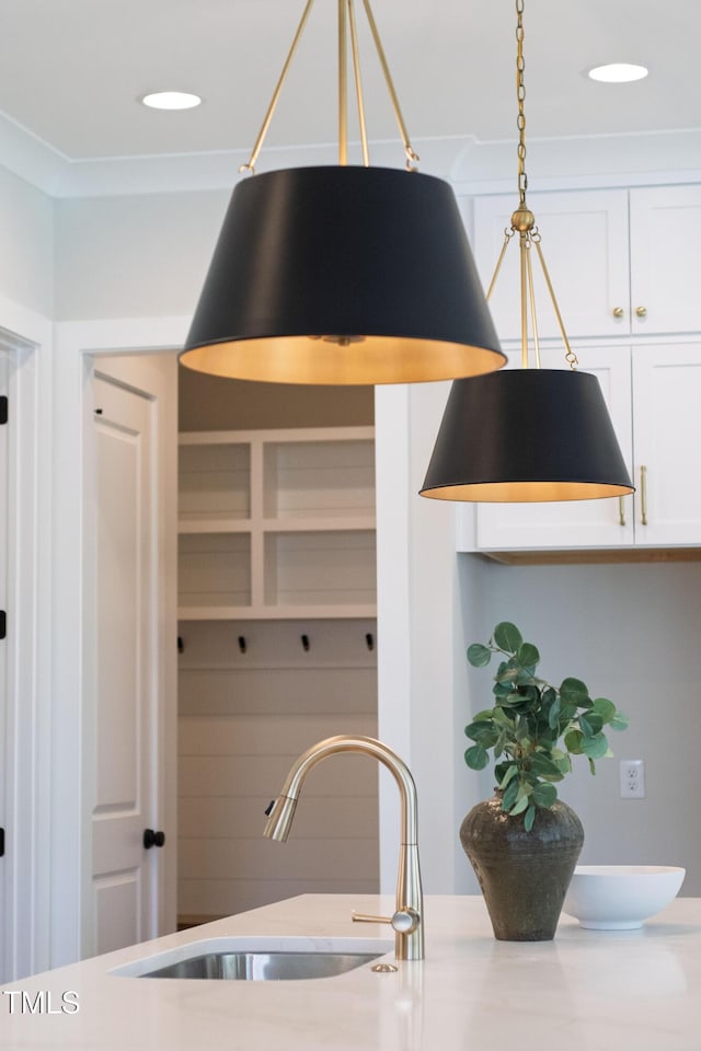 room details featuring recessed lighting, light countertops, a sink, and white cabinetry