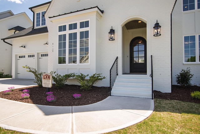 doorway to property featuring concrete driveway and brick siding