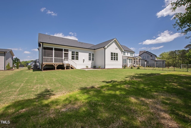 back of house with fence, a shingled roof, a sunroom, and a yard