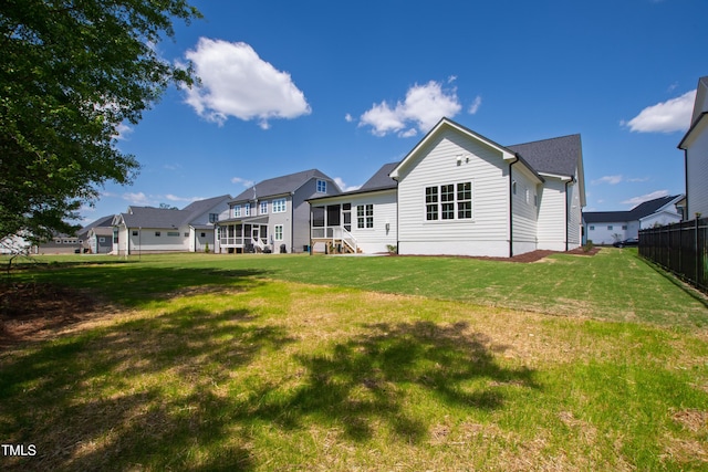 back of house featuring a lawn and fence