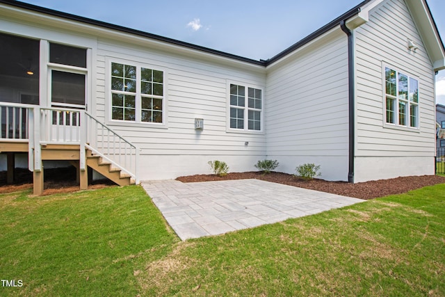 rear view of house featuring a patio area and a lawn