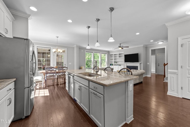 kitchen with appliances with stainless steel finishes, a sink, a ceiling fan, crown molding, and a fireplace