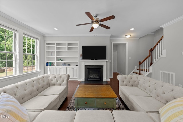 living room with a ceiling fan, ornamental molding, recessed lighting, a fireplace with flush hearth, and dark wood-style flooring