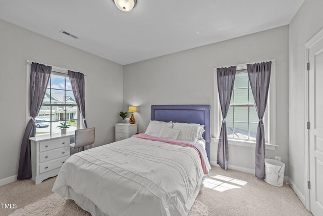 bedroom with light colored carpet and baseboards