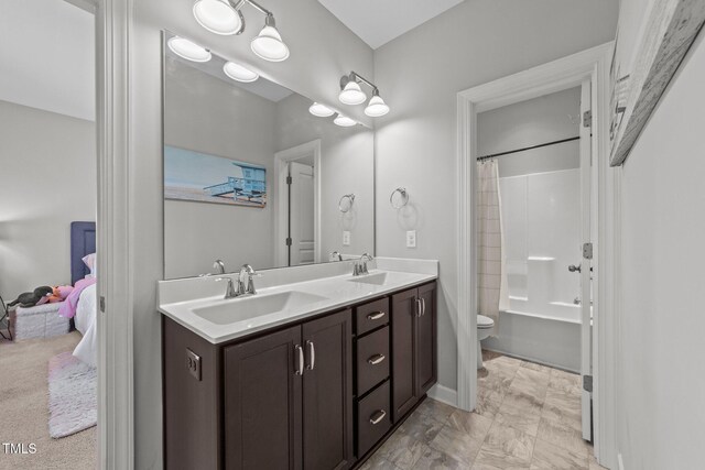 full bathroom with double vanity, toilet, marble look tile flooring, and shower / tub combo