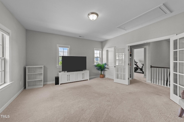 unfurnished living room with attic access, carpet floors, baseboards, and french doors