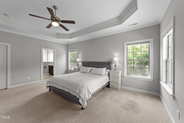 bedroom with a tray ceiling, crown molding, multiple windows, light colored carpet, and baseboards