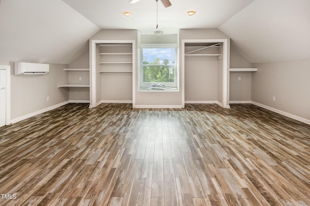 bonus room featuring a wall mounted AC, baseboards, vaulted ceiling, ceiling fan, and wood finished floors