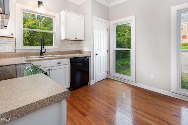 kitchen featuring light wood-style floors, dishwasher, a sink, and ornamental molding