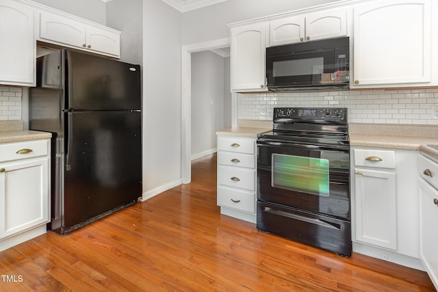 kitchen with ornamental molding, light countertops, black appliances, white cabinetry, and backsplash