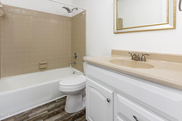 bathroom with toilet, vanity, wood finished floors, and  shower combination