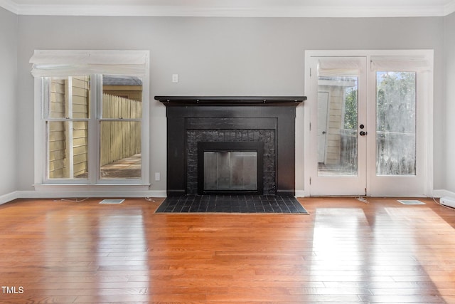 unfurnished living room featuring visible vents, ornamental molding, and hardwood / wood-style flooring