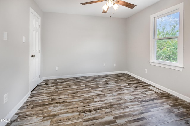 spare room featuring wood finished floors, baseboards, and a ceiling fan