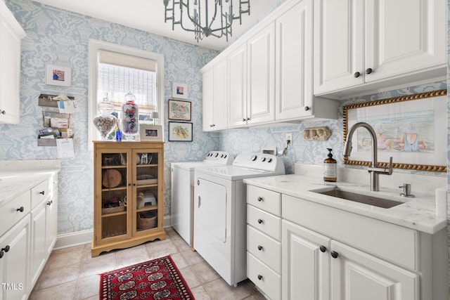 laundry room with cabinet space, wallpapered walls, separate washer and dryer, a chandelier, and baseboards