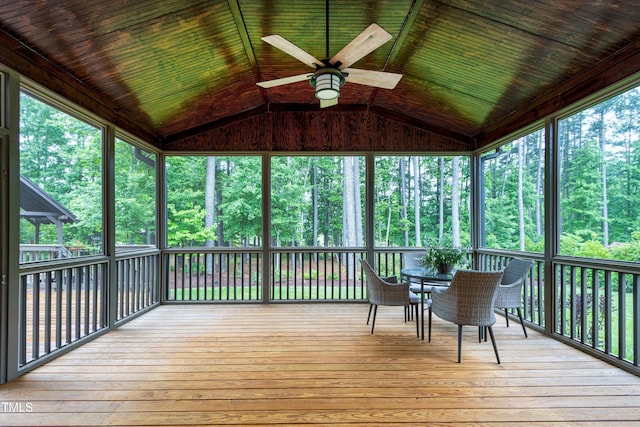 sunroom / solarium featuring a ceiling fan, lofted ceiling, and outdoor dining space