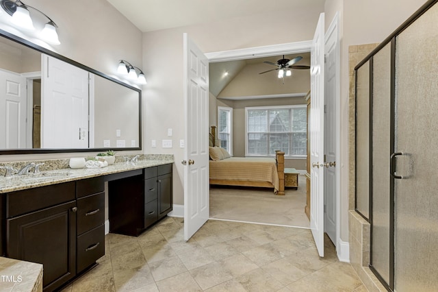 ensuite bathroom featuring a ceiling fan, double vanity, baseboards, a stall shower, and lofted ceiling