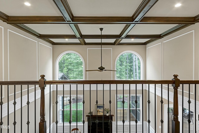 detailed view of a decorative wall, coffered ceiling, beam ceiling, and ceiling fan