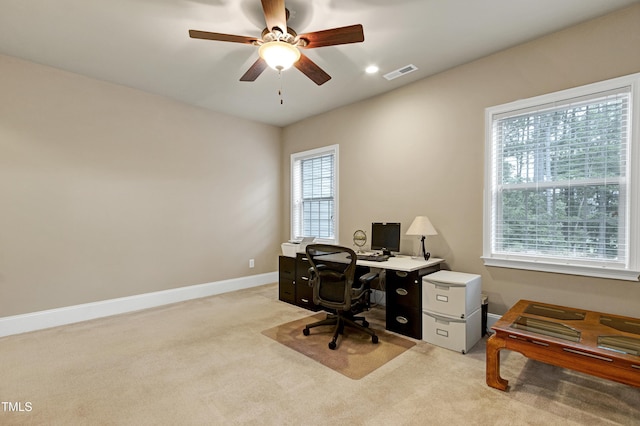 office featuring light carpet, a ceiling fan, and baseboards