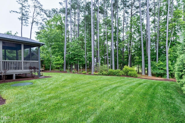 view of green lawn featuring a sunroom