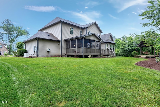 back of property with a sunroom, a lawn, and central AC unit