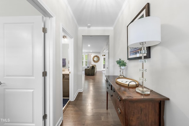 hall with crown molding, dark wood finished floors, and baseboards
