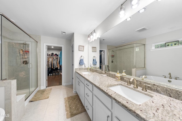 full bath with visible vents, a sink, a stall shower, and double vanity