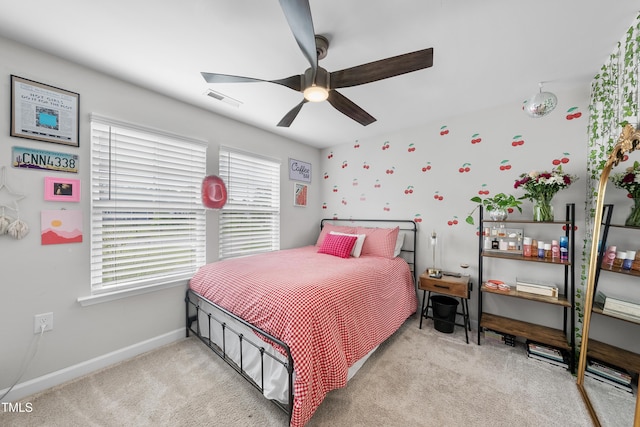 bedroom featuring baseboards, visible vents, multiple windows, and light carpet