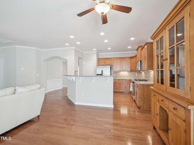 519 Garendon Dr, Cary, NC 27519 - kitchen with a ceiling fan, crown molding, appliances with stainless steel finishes, arched walkways, and open floor plan
