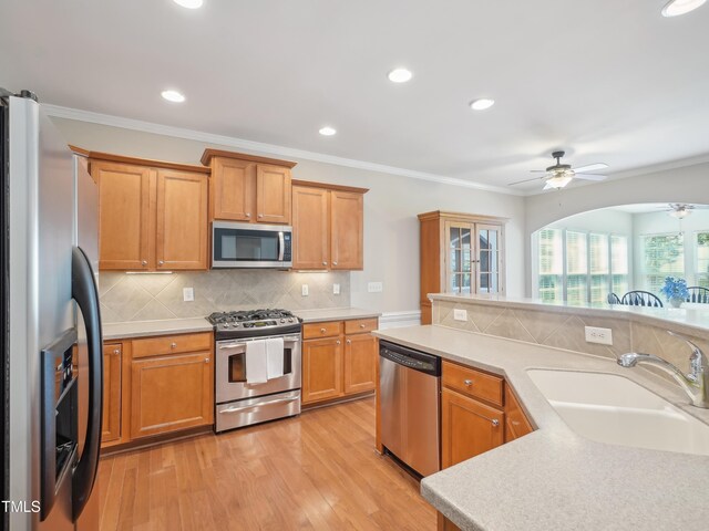 519 Garendon Dr, Cary, NC 27519 - kitchen featuring crown molding, light wood-style floors, light countertops, a sink, and appliances with stainless steel finishes