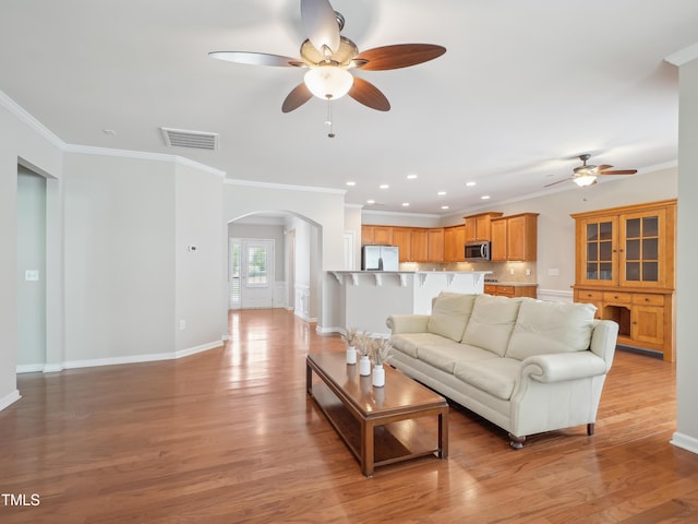 519 Garendon Dr, Cary, NC 27519 - living area featuring a ceiling fan, visible vents, arched walkways, ornamental molding, and light wood-style flooring