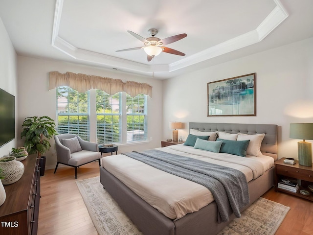 519 Garendon Dr, Cary, NC 27519 - bedroom with ornamental molding, a tray ceiling, light wood finished floors, and ceiling fan