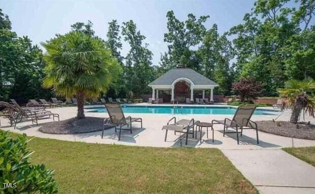 community pool featuring a yard and a patio area